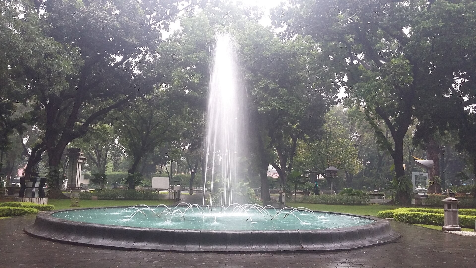 Air mancur di antara pepohonan Taman Suropati